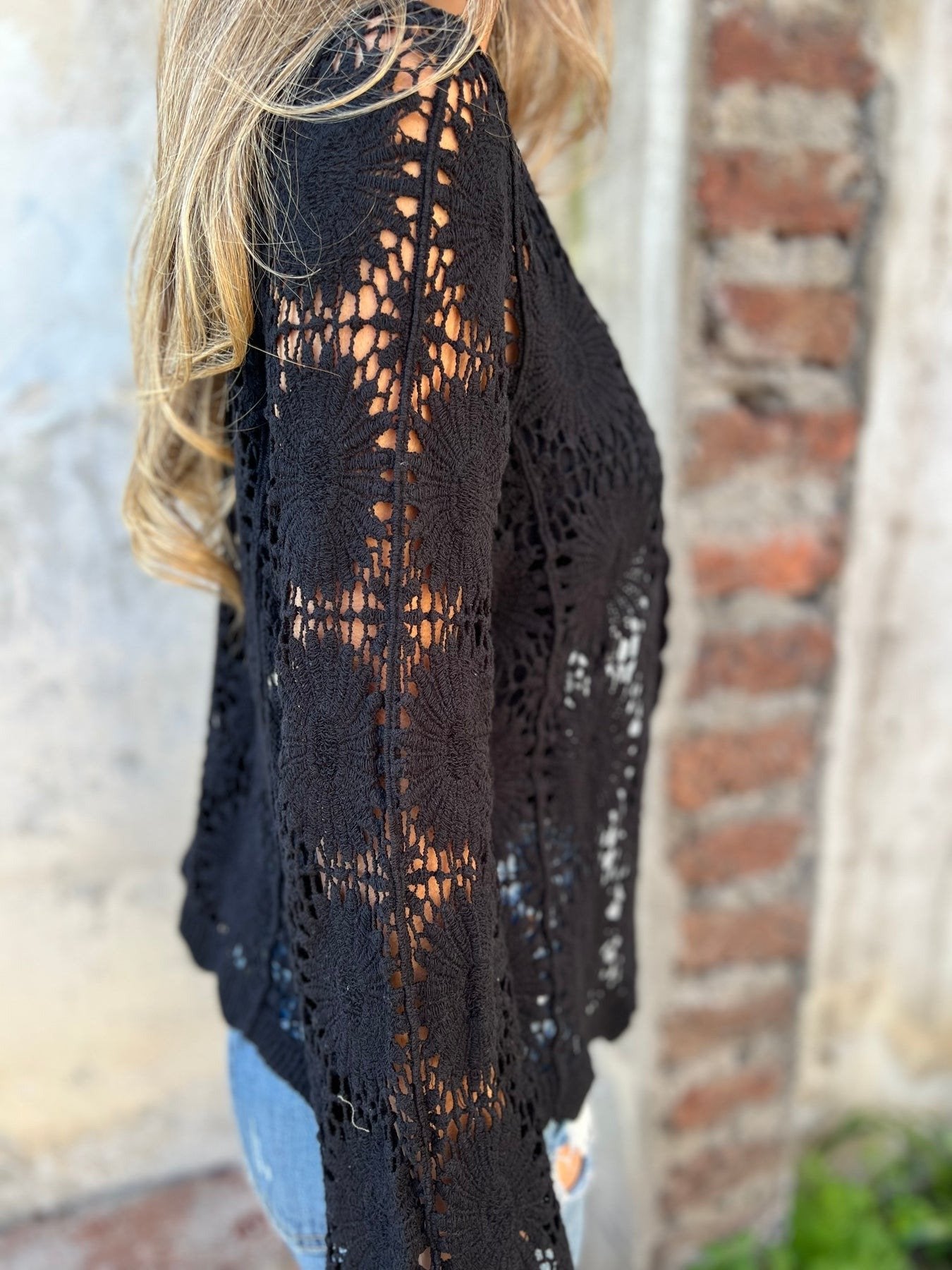 Izrezan top z dolgimi rokavi in vezenim V-izrezom ter gumbi